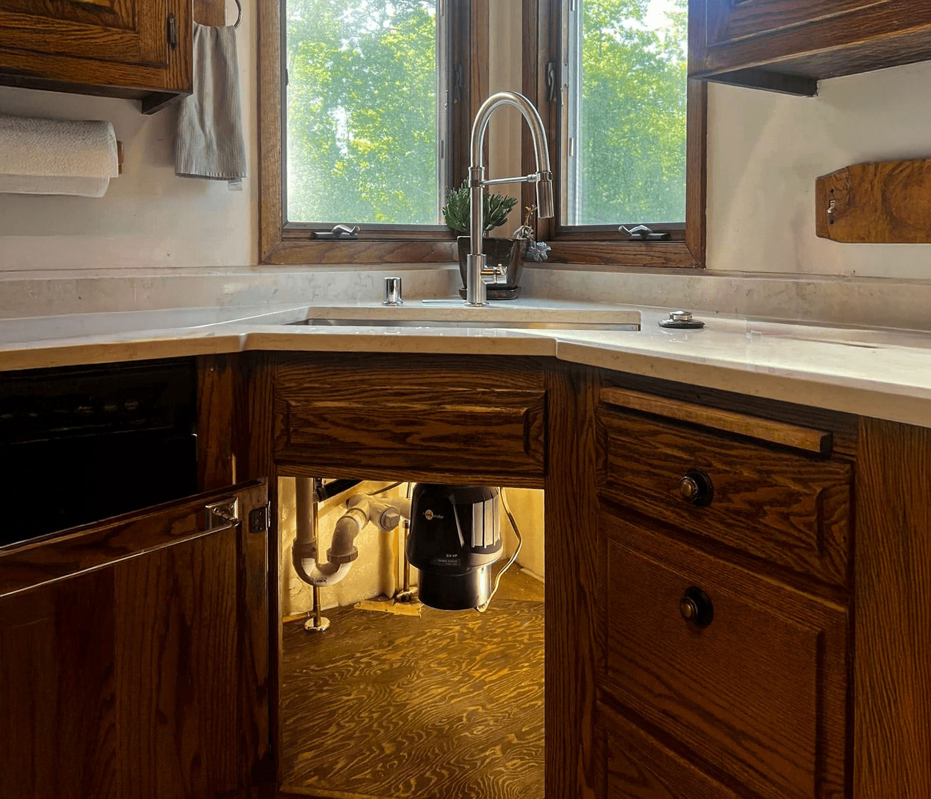 Under-sink plumbing work completed in a residential kitchen